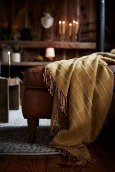 a living room filled with furniture and a blanket on top of a chair in front of a fire place