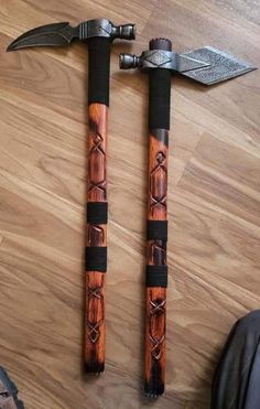 two large wooden axes sitting next to each other on top of a wood floor covered floor