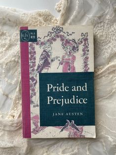 the book pride and prejudice by jane austen is laying on a lace covered surface