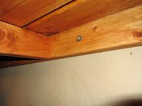 a metal refrigerator freezer sitting under a wooden ceiling