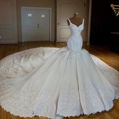 a wedding dress is displayed on a mannequin in the middle of a room