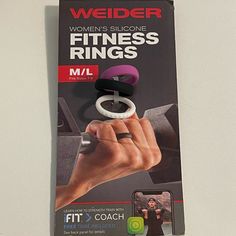 a book about women's fitness rings on a white surface with a hand holding the ring