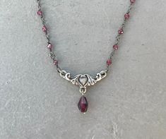 This dainty necklace is handmade using a 2mm genuine garnet rosary chain and a 18mm x 9mm heart connector with a 5mm garnet drop charm. A gold version is also available in my shop. This necklace is hypoallergenic. (Cadium free, lead free, and nickel safe) Garnet is an energizing stone that promotes passion and love.  The necklace comes in a ribbon-wrapped box, ready to be gifted. If you would like to leave a note for the recipient, you can do so during checkout. Garnet Rosary, Necklace With Charms, Jewelry Fancy, Etsy Jewellery, Edgy Jewelry, Rosary Necklace, Crystal Necklaces, Garnet Necklace, Nail Jewelry