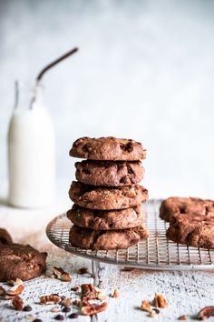 a stack of cookies sitting on top of a cooling rack next to a bottle of milk