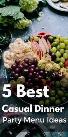 a platter filled with grapes, pears and other fruit on top of a table