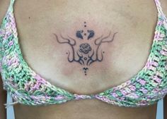 a woman's back with a tattoo design on her left shoulder and the bottom part of her bra