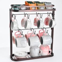 a rack with cups and mugs hanging from it's sides in front of a white background