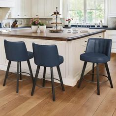 three stools sit at the center of a kitchen island