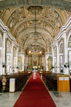 the inside of a church with pews and red carpet