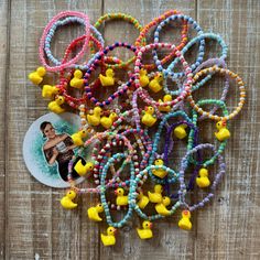 a bunch of bracelets with rubber ducks attached to them on a wooden table next to a photo