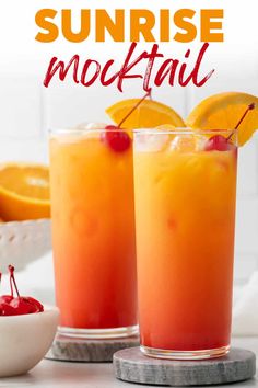 two glasses filled with orange juice and garnished with cherries on the rim