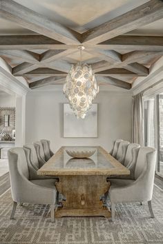 a dining room table with chairs and a chandelier hanging from the ceiling