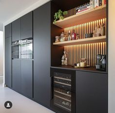 a kitchen with black cabinets and shelves filled with food