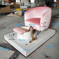 a pink and gold chair sitting on top of a white platform with measurements for the seat