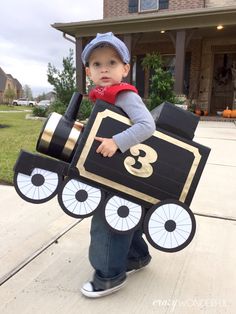 a young boy is dressed up as a train with numbers on the front and sides