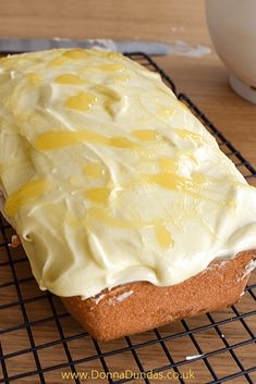 a loaf of lemon cake sitting on top of a cooling rack