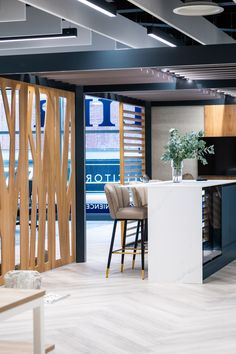 an open kitchen and dining room area with white counter tops, blue cabinets and bar stools