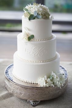 a three tiered wedding cake with white flowers on top