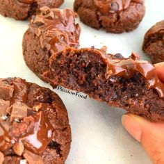 someone is holding up a chocolate cookie that has been cut in half to show the inside