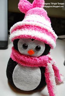 a stuffed penguin wearing a pink hat and scarf