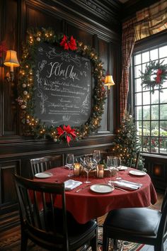 a dining room with a christmas wreath on the wall and table set for two, surrounded by holiday decorations