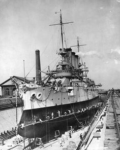 an old photo of a large ship docked at a dock with people standing on the deck