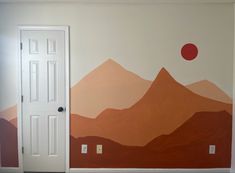 an empty room with mountains painted on the wall and a door in front of it