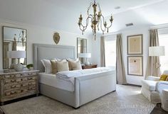 a bedroom with white furniture and chandelier