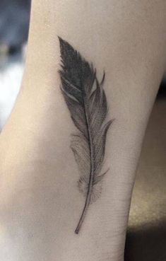 a small feather tattoo on the ankle