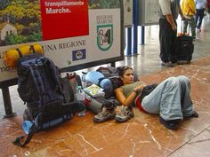 a woman laying on the ground next to luggage