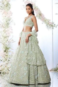 Tea green lehenga featuring all-over blue floral sequin motifs with crystal and pearl embroidery. Paired with a blouse and four-sided embroidered net dupatta. Component: 3 Pattern: Embroidered Type Of Work: Floral Motifs Neckline: V-neck Sleeve Type: Sleeveless Fabric: Net Color: Green Other Details:  Tassel hem blouse Back tassel tie-up blouse Floral motifs Note: Only selling the product mentioned in the description from the video. Occasion: Wedding - Aza Fashions Pastel Green Indian Outfit, Pastel Green Lehenga, Green Lehengas, Sage Green Lehenga, Pista Green Lehenga, Green Lengha, Dirac Somali, Dandiya Night, Lehenga Green