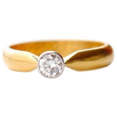 a gold ring with a diamond in the middle and a small white diamond on top