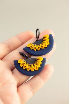 two small sunflowers are sitting in the palm of someone's hand