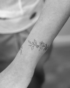 a woman's arm with a small flower tattoo on the left side of her wrist