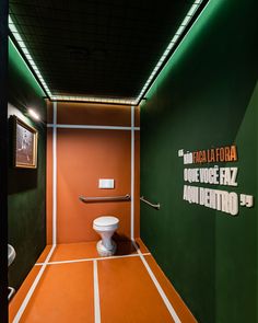 an orange and green bathroom with a toilet