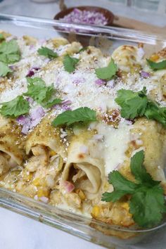 a casserole dish with chicken, cheese and cilantro sprinkled on top