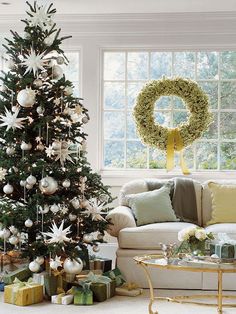 a living room with a christmas tree in the corner and a wreath on the window sill