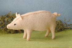 a small toy pig standing next to some hay