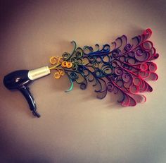 a hair dryer is sitting on top of some scissors and curlers in the shape of a peacock