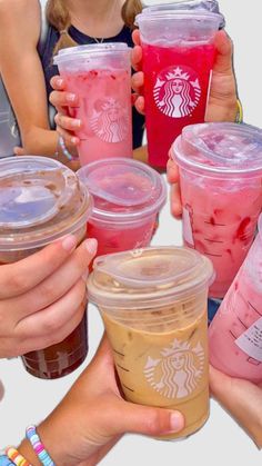 several people holding up cups with drinks in them