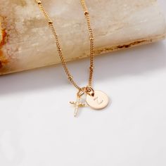 Ready to express yourself? With the Josephine Initial Cross Pendant, you can wear your special symbol of faith and style, wherever you go. Featuring a fine CZ cross and initial, this eye-catching piece is perfect for making an unforgettable statement! Josephine Cross Charm: Available in 14k gold vermeil and sterling silver, Charm size: 1/4"x1/2", 1mm white CZ Madeline Initial Pendant: 3/8" gold filled and sterling silver disc, Hand stamped initial, 16" brass satellite chain with 2" extender Lobs Personalized Rose Gold Cross Jewelry, Personalized 14k Gold Cross Jewelry, Tennis Jewelry, Modern Jewellery Design, Special Symbols, Gold Cross Pendant, Initial Pendant, Cross Charms, Letter Necklace