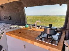 the interior of a camper van with a stove and table in front of it