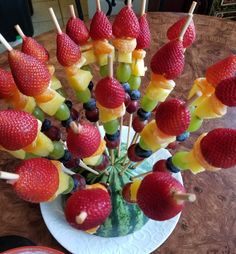 fruit skewers are arranged in a bowl on a table