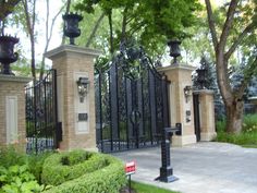 an iron gate is surrounded by lush green plants