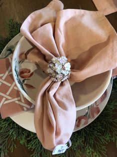 the napkins are folded on top of each other in front of a plate with an ornament