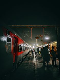 people are standing at the train station waiting for their trains to come in and out