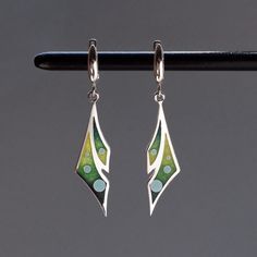 100% handmade sterling silver earrings, covered with hot cloisonné enamel. Cloisonné  is an ancient technique for decorating metalwork objects with colored material held in place or separated by metal strips or wire, normally of gold or silver. This process is quite laborious, because all the details require hand processing. Georgian cloisonné enamel counts more than 1200 years of history.  Our handmade pendants, earrings, brooches are vibrant with colour and compliment any outfit, prefered for daily wear or a special occasion. Materials: Sterling Silver, Fine Silver, Cloisonne enamel Earrings: Weight - 5.6 gr (approx) Drop Lenght - 3.6 cm; 1.4 inches  Lenght - 5 cm; 2 inches Width - 1.1 cm; 0.45 inches  Pendant; Weight - 2.5 gr (approx) Lenght -  3.6cm; 1.4 inches (without bail) Width - 1 Artistic Enamel Earrings Nickel-free, Green Enamel Earrings With Artistic Design, Green Dangle Earrings With Artistic Design, Green Artistic Dangle Earrings, Artistic Green Sterling Silver Earrings, Green Hand Painted Sterling Silver Earrings, Artistic Enamel Jewelry With Matching Earrings, Artistic Enamel Drop Earrings, Artistic Enamel Jewelry With Earrings