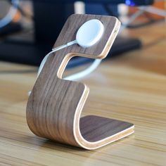 a wooden phone stand with an ipod plugged into it