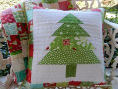 a green christmas tree pillow sitting on top of a white chair