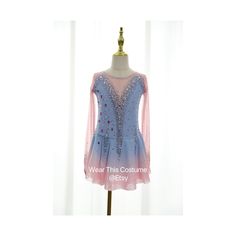 a blue and pink dress with sequins on the shoulders, sitting on a mannequin